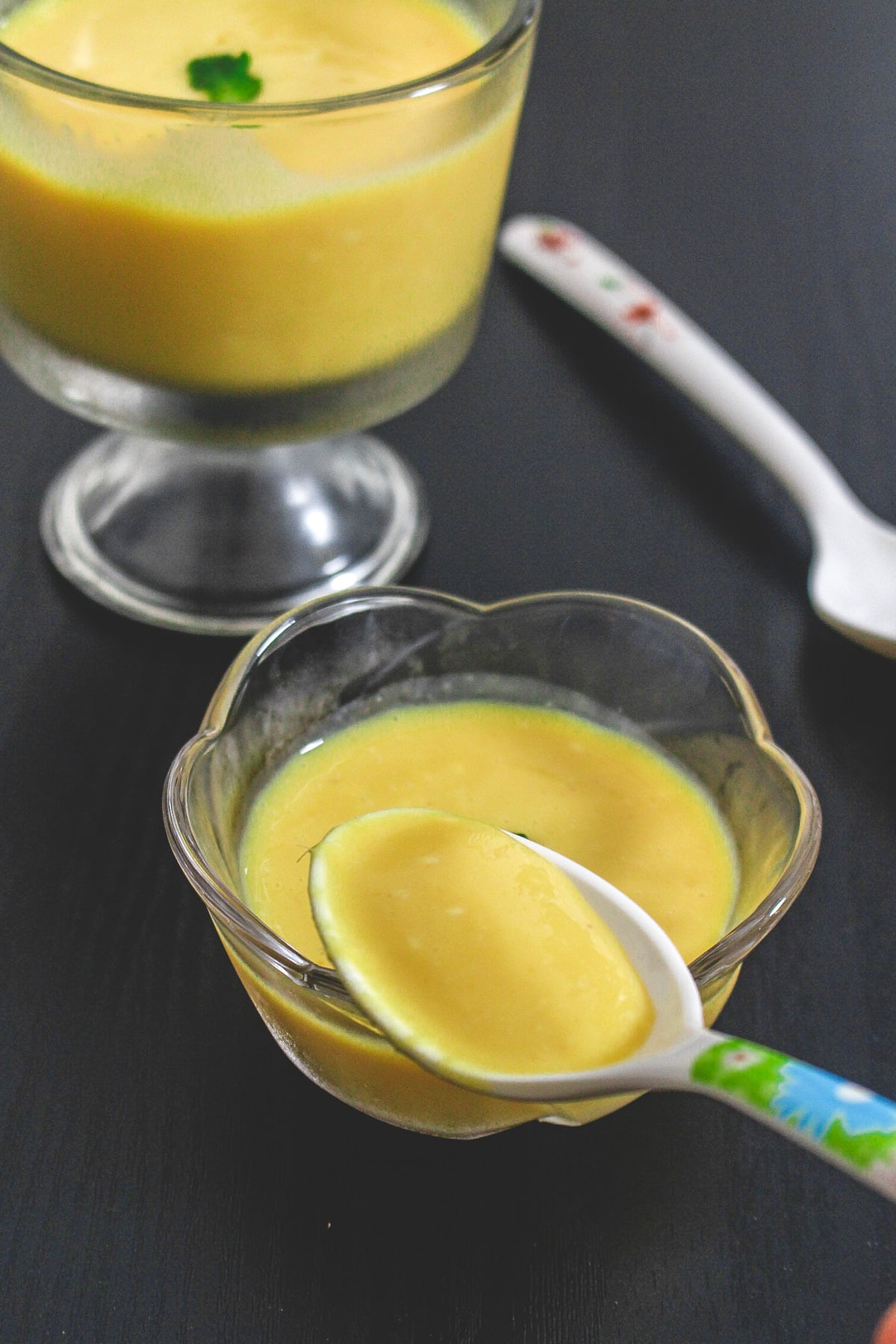 A spoonful of mango pudding taken from the bowl to show thick texture.