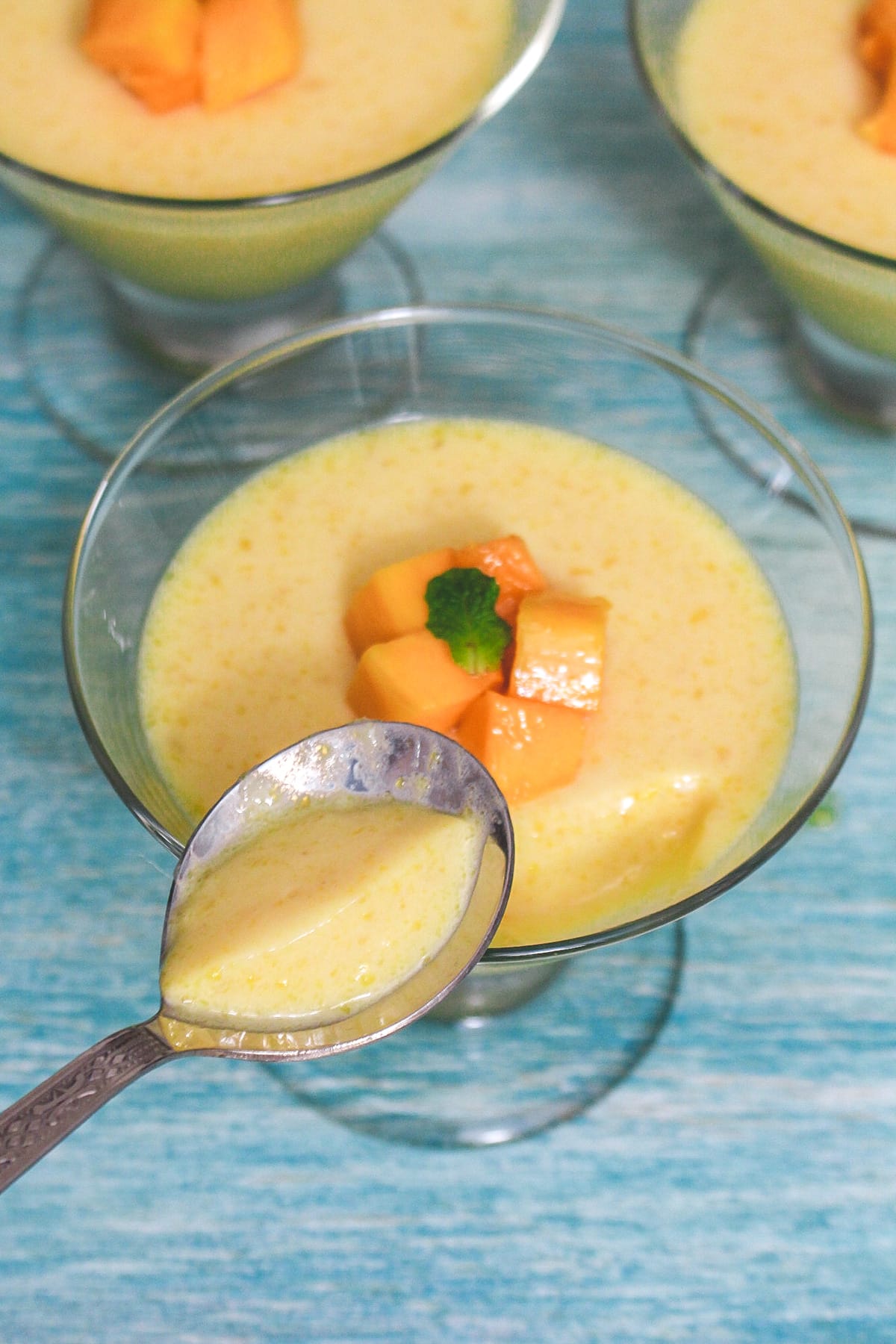 A spoonful of mango pudding taken from the bowl to show texture.