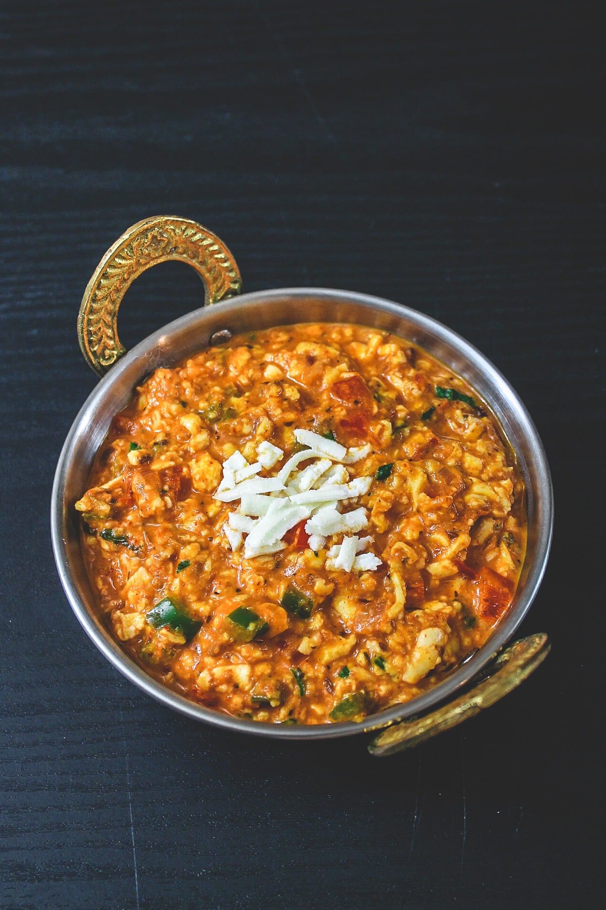 Paneer bhurji gravu served in kadai serving bowl.