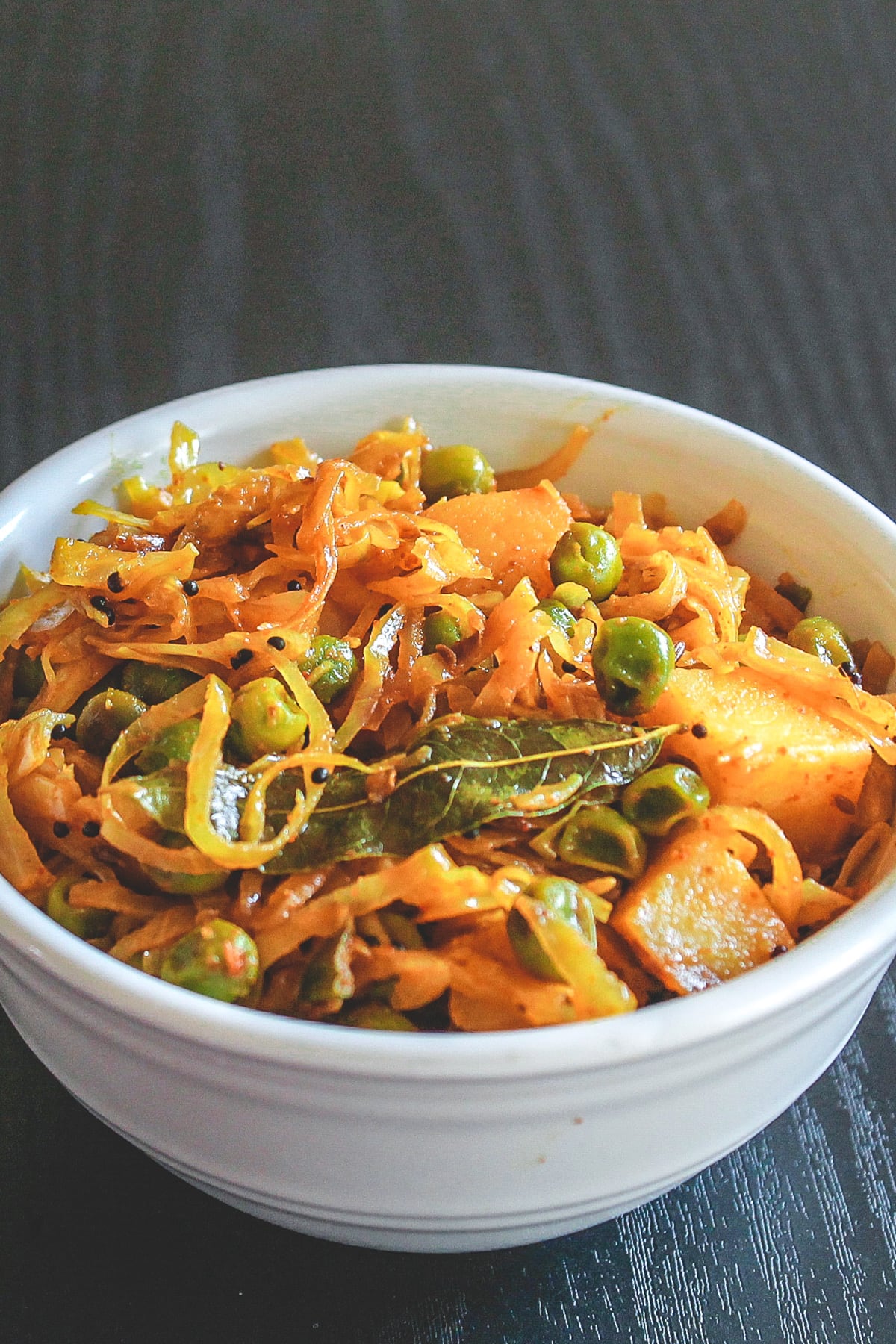 Cabbage sabzi served in a white bowl.