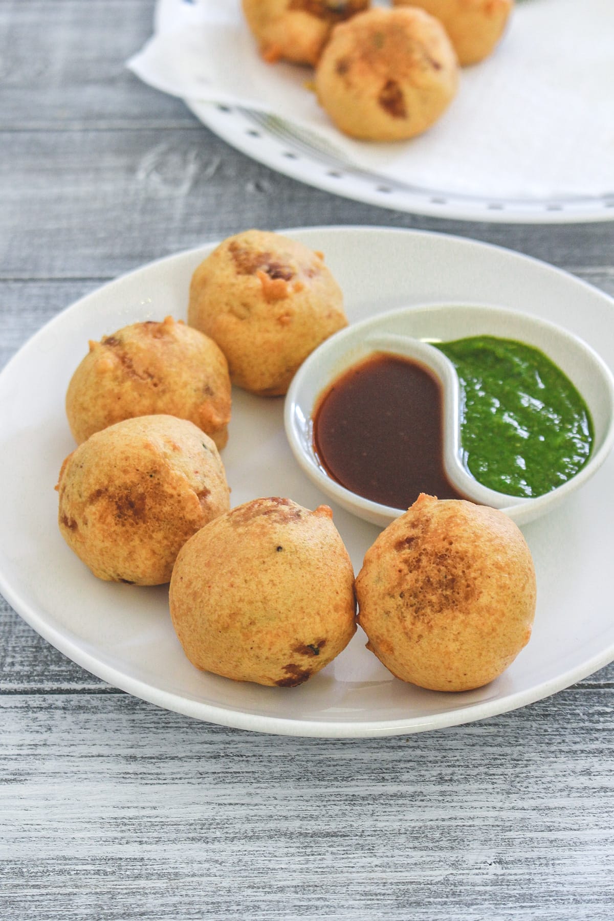 5 batata vada seved with green chutney and meethi chutney.