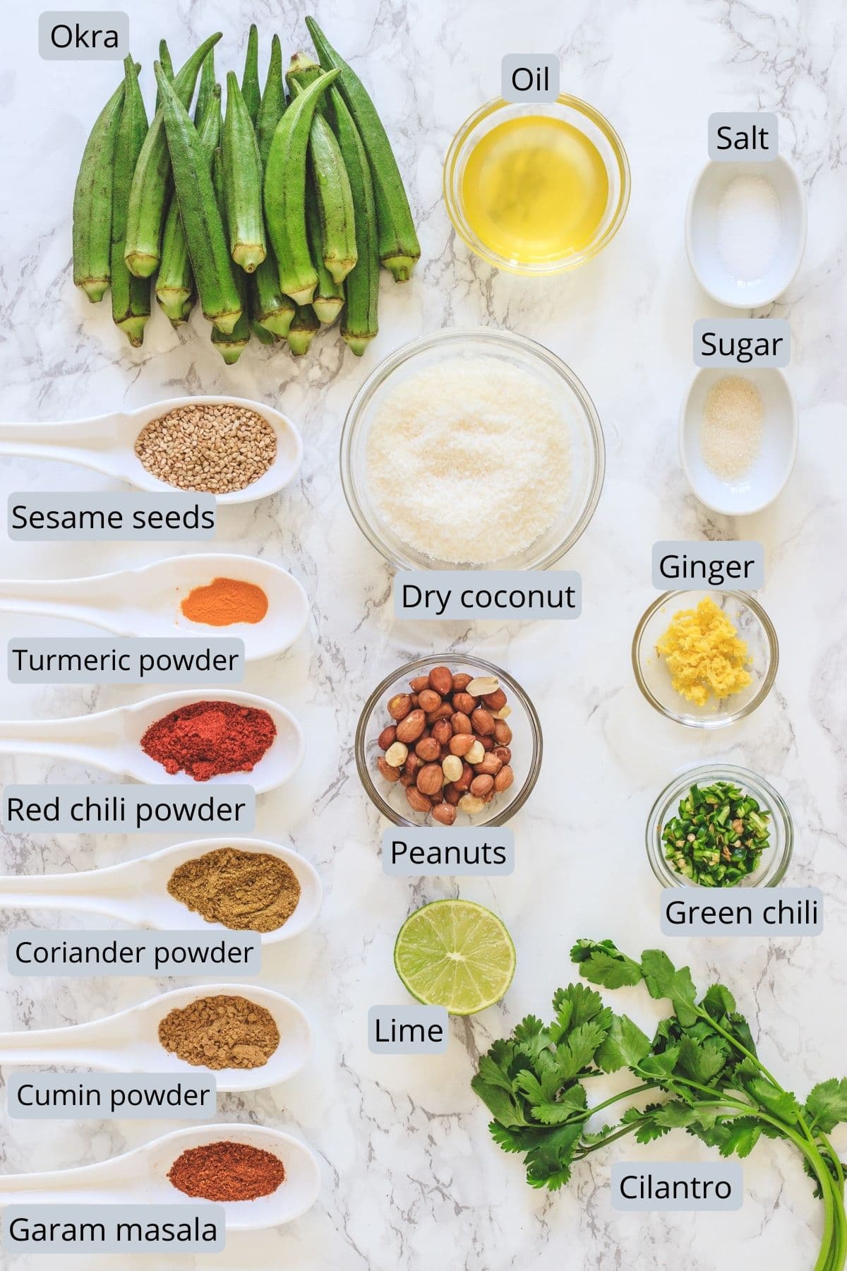 Bharwa bhindi ingredients with labels on the marble surface.