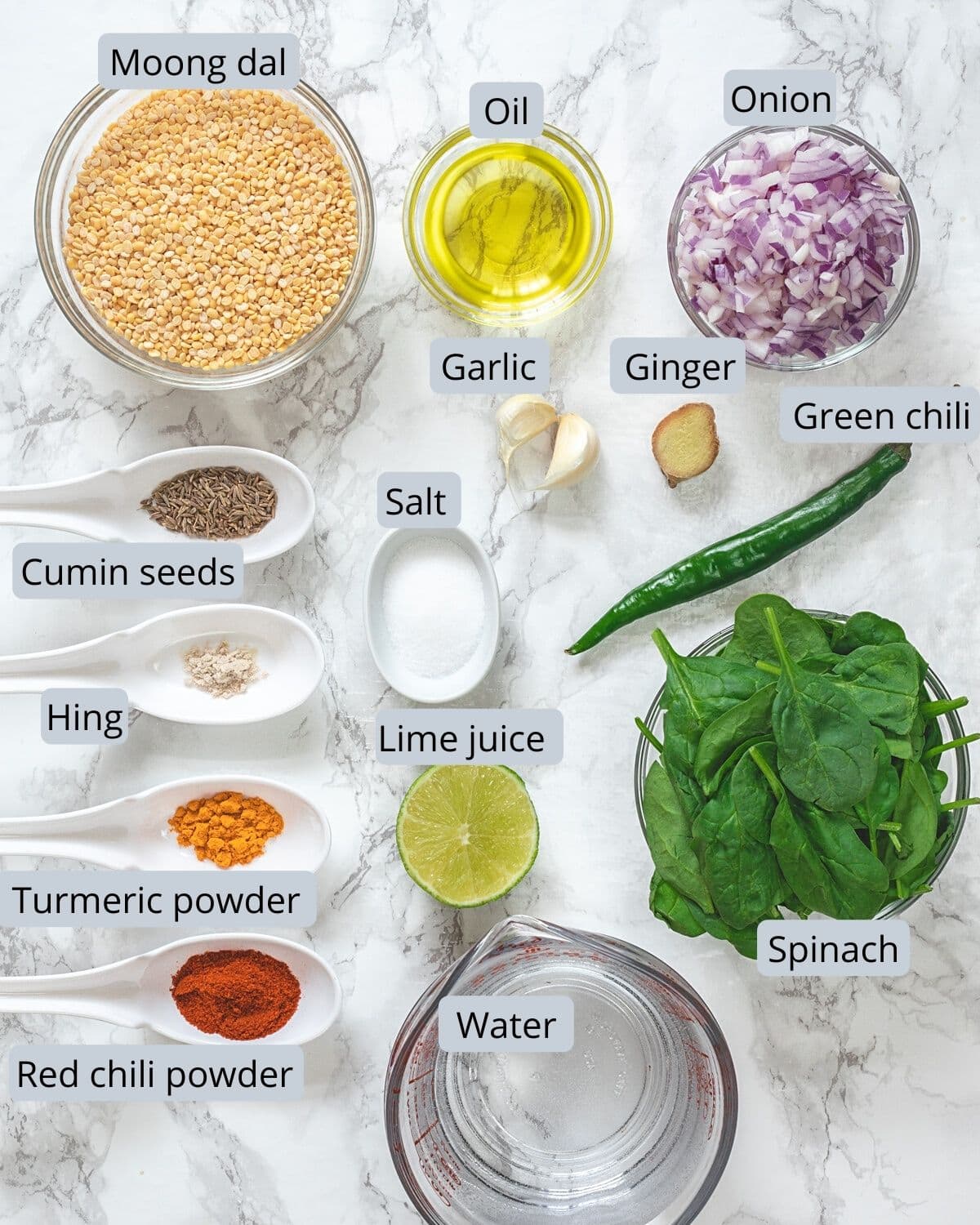 Dal palak ingredients with labels on a marble surface.