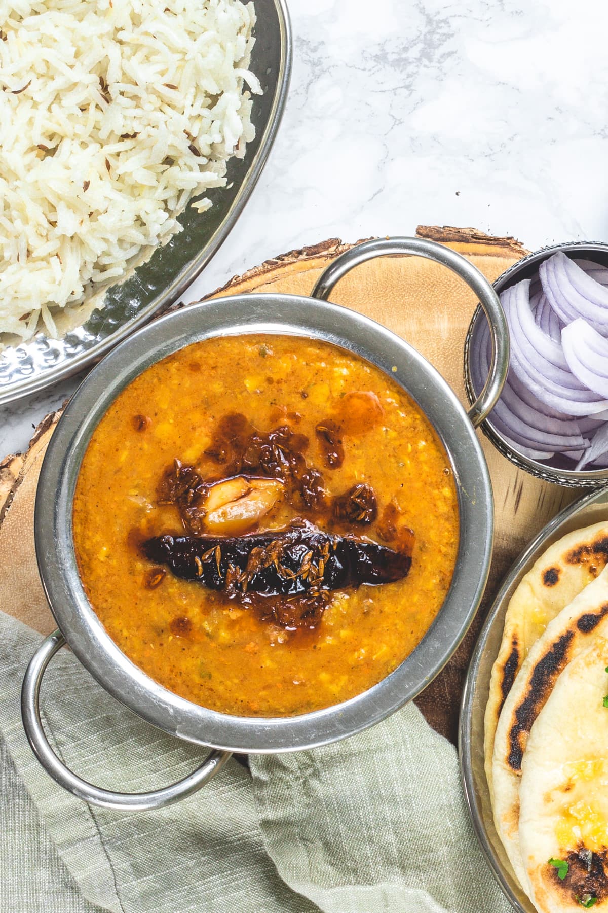 Dal tadka served with rice, sliced onions and naan.