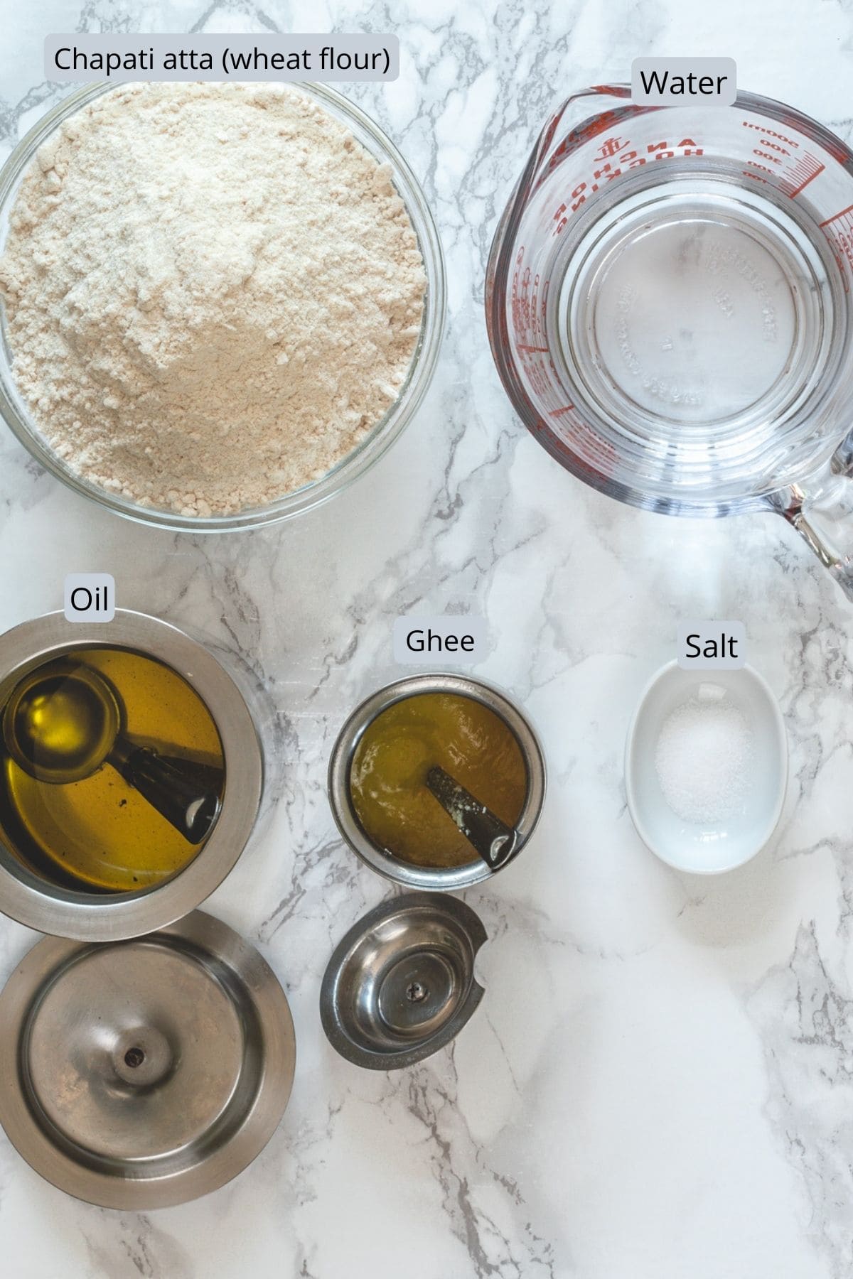 Phulka roti ingredients with labels on a marble surface.