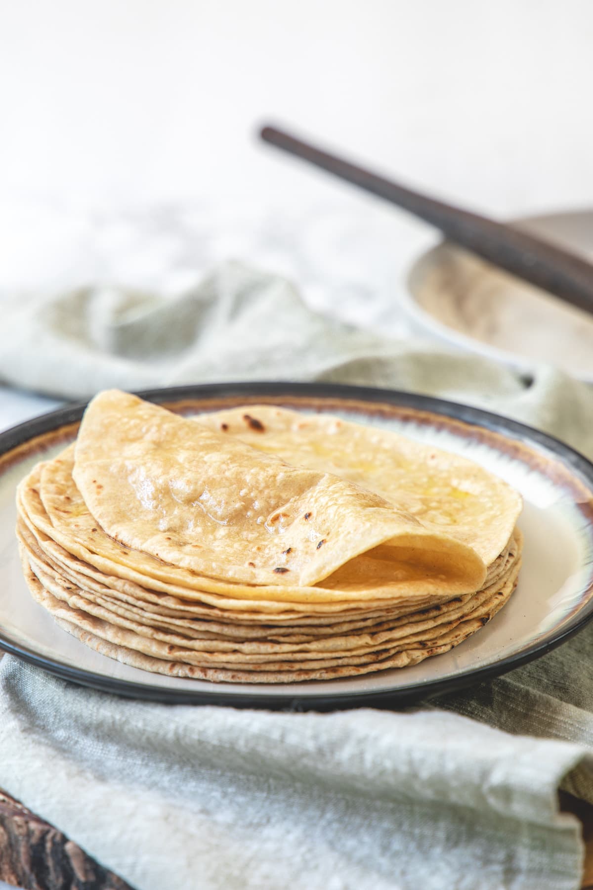 A stack of roti with top roti is folded in half.