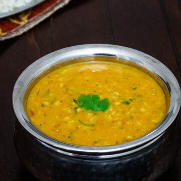 Dhaba style urad dal served with jeera rice in the back.