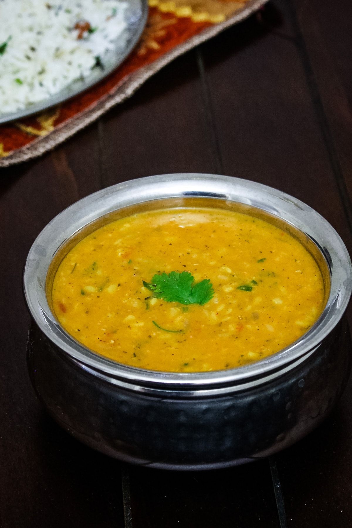 Dhaba style urad dal served with jeera rice in the back.