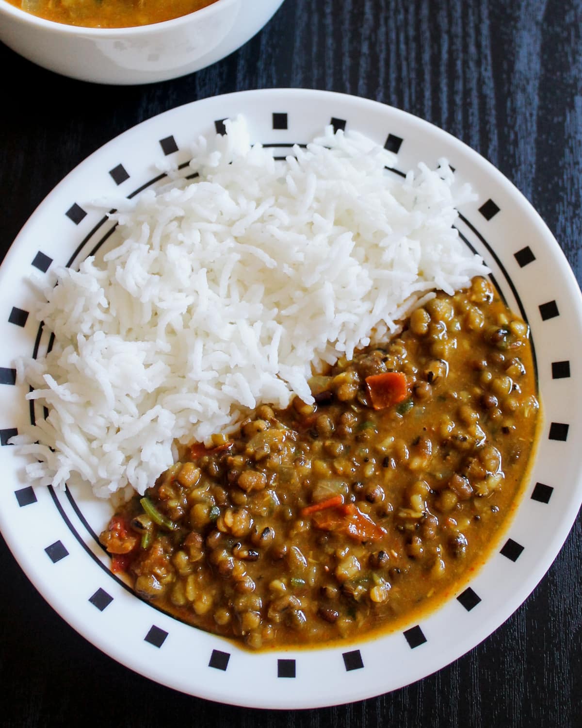 Green moong dal and plain rice served in a plate.