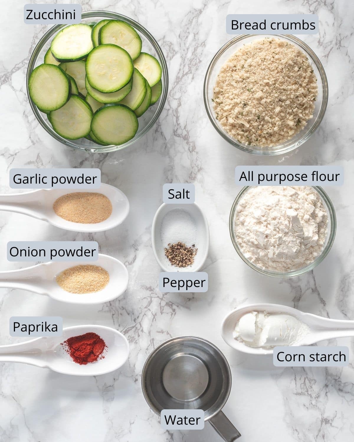 Air fryer zucchini chips ingredients in bowls and spoons with labels.