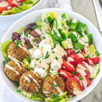 Falafel salad bowl with a drizzle of tahini sauce.