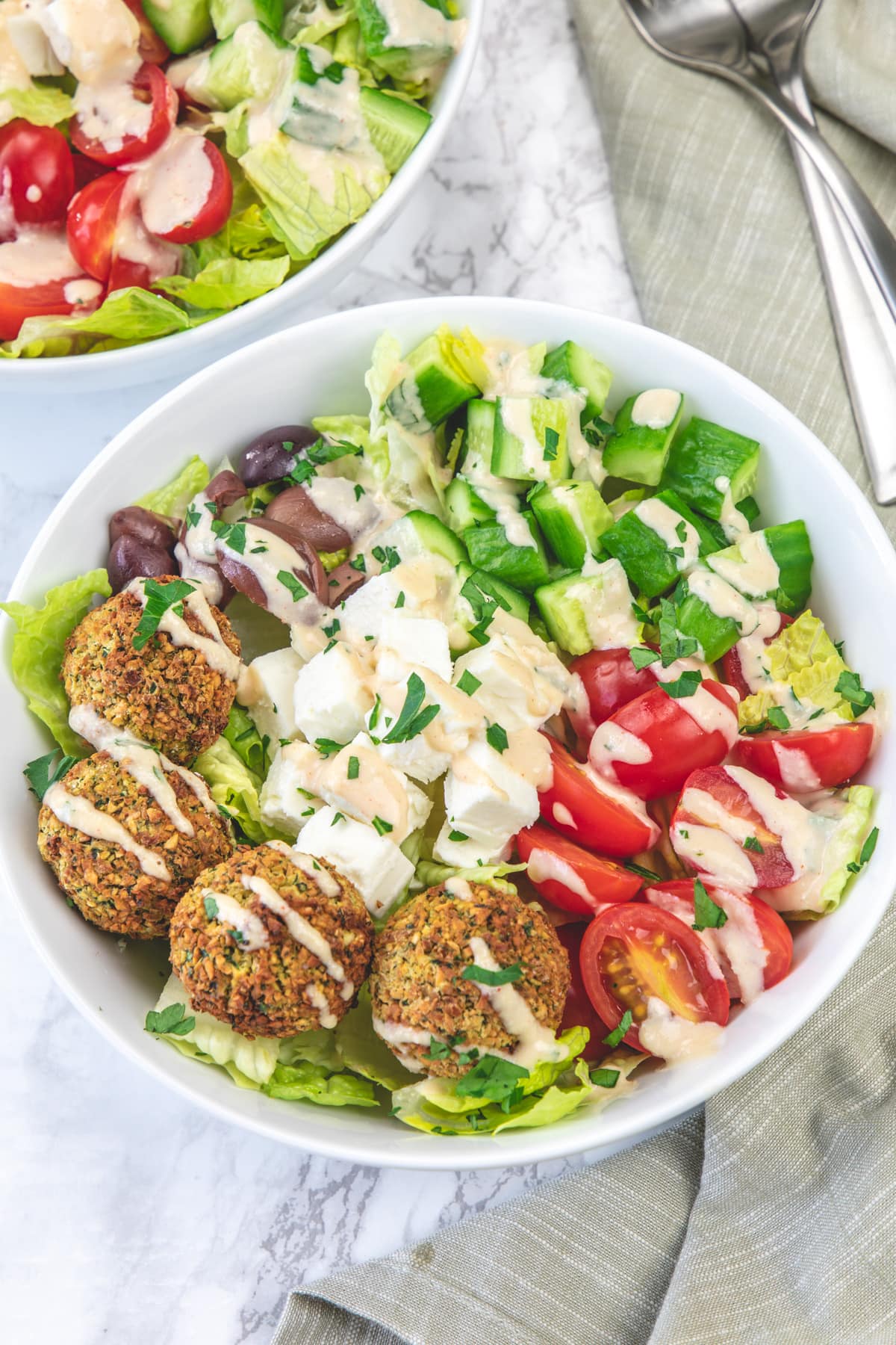 Falafel salad bowl with a drizzle of tahini sauce.