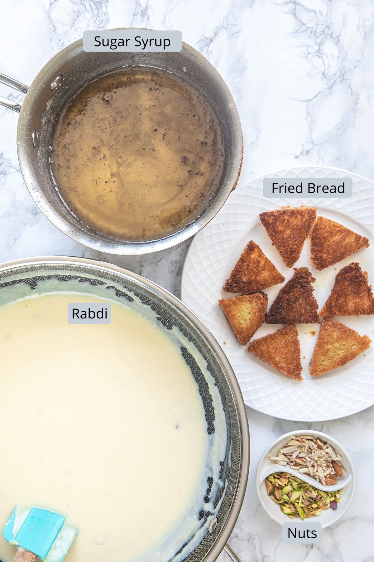 Shahi tukda elements sugar syrup, fried bread, rabri and chopped nuts.