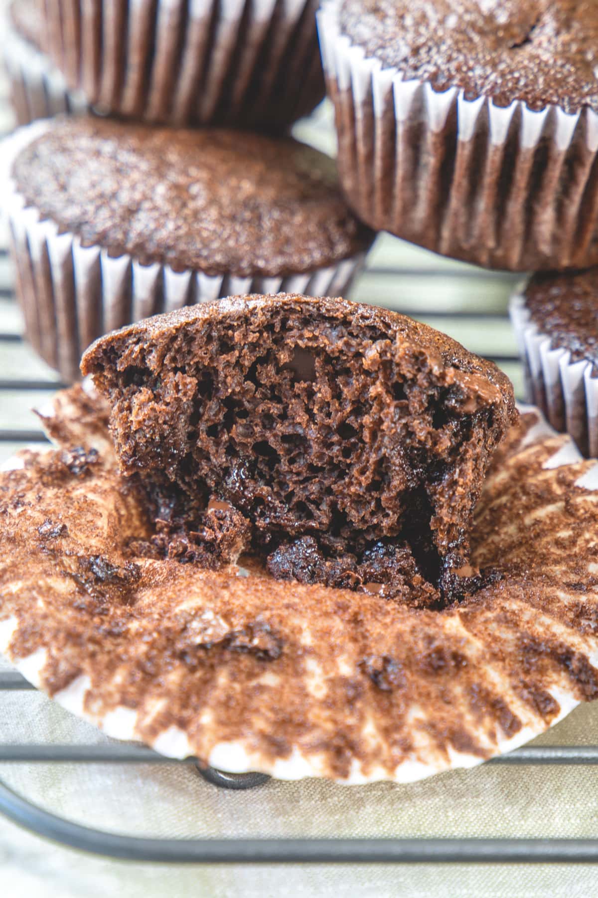 Cup open half eggless chocolate muffin to show texture.