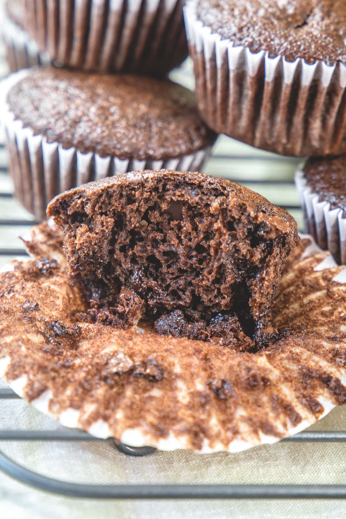 Cup open half eggless chocolate muffin to show texture.