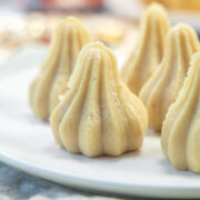 Kaju modak in a white plate.