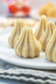 Kaju modak in a white plate.