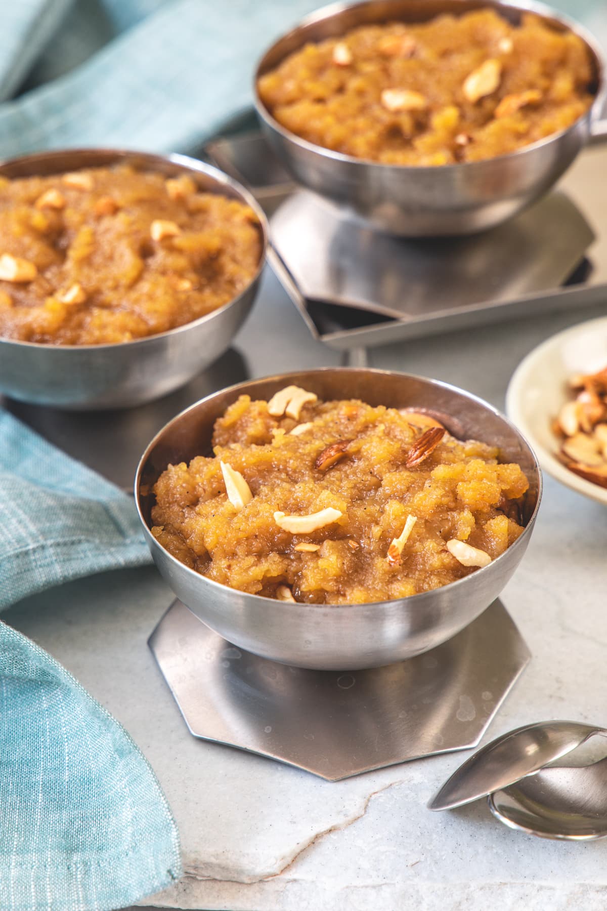 3 bowls of moong dal halwa with napkin on side.