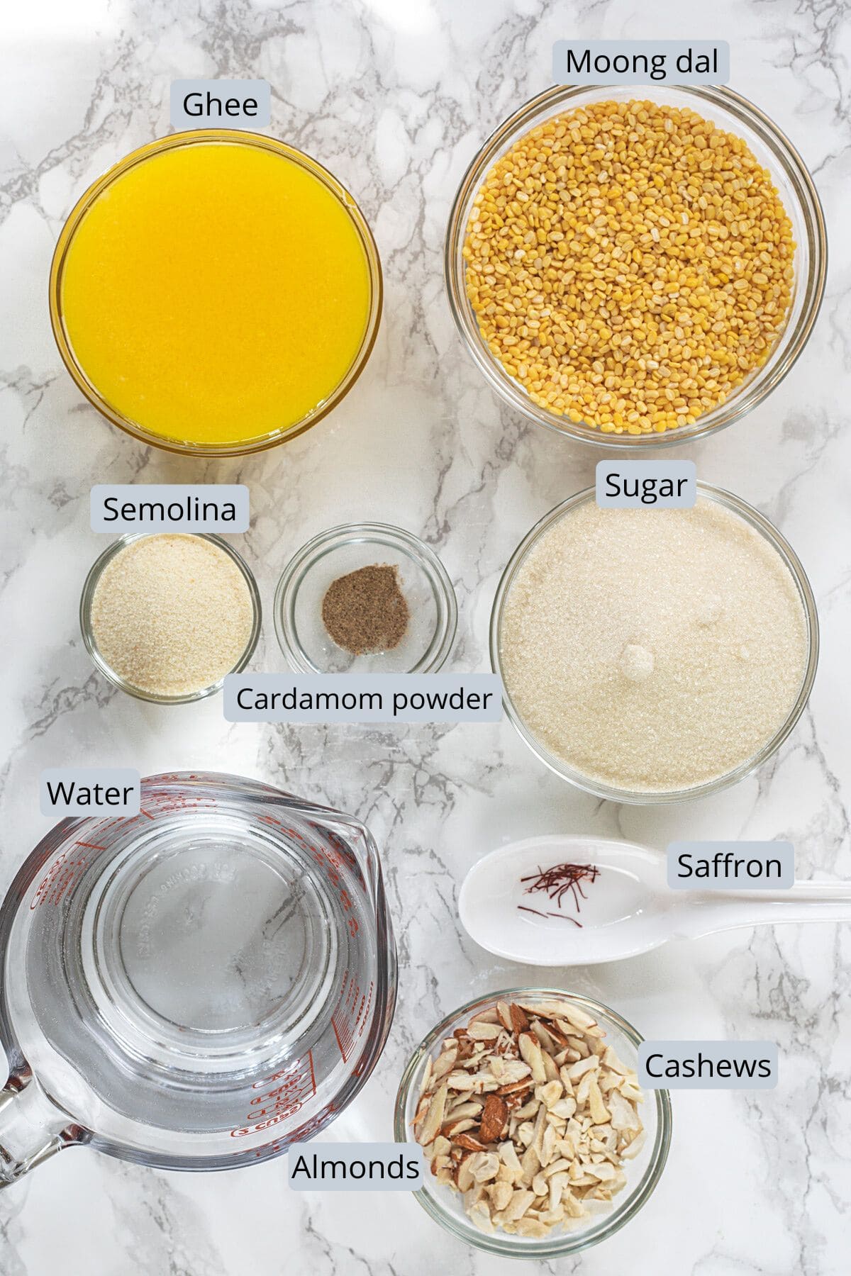 Moong dal halwa ingredients in bowls and spoons with label.