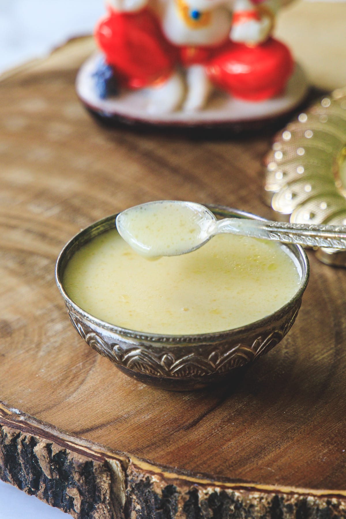 Panchamrut taking with a silver spoon.