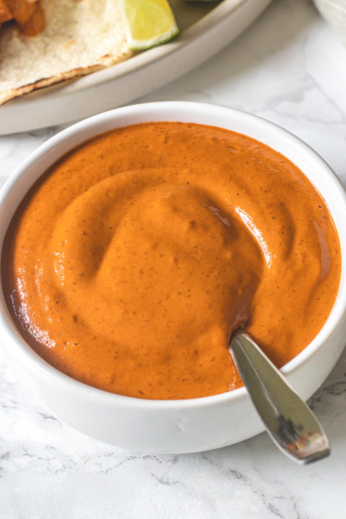 Chipotle sauce in a bowl with a spoon in the bowl.