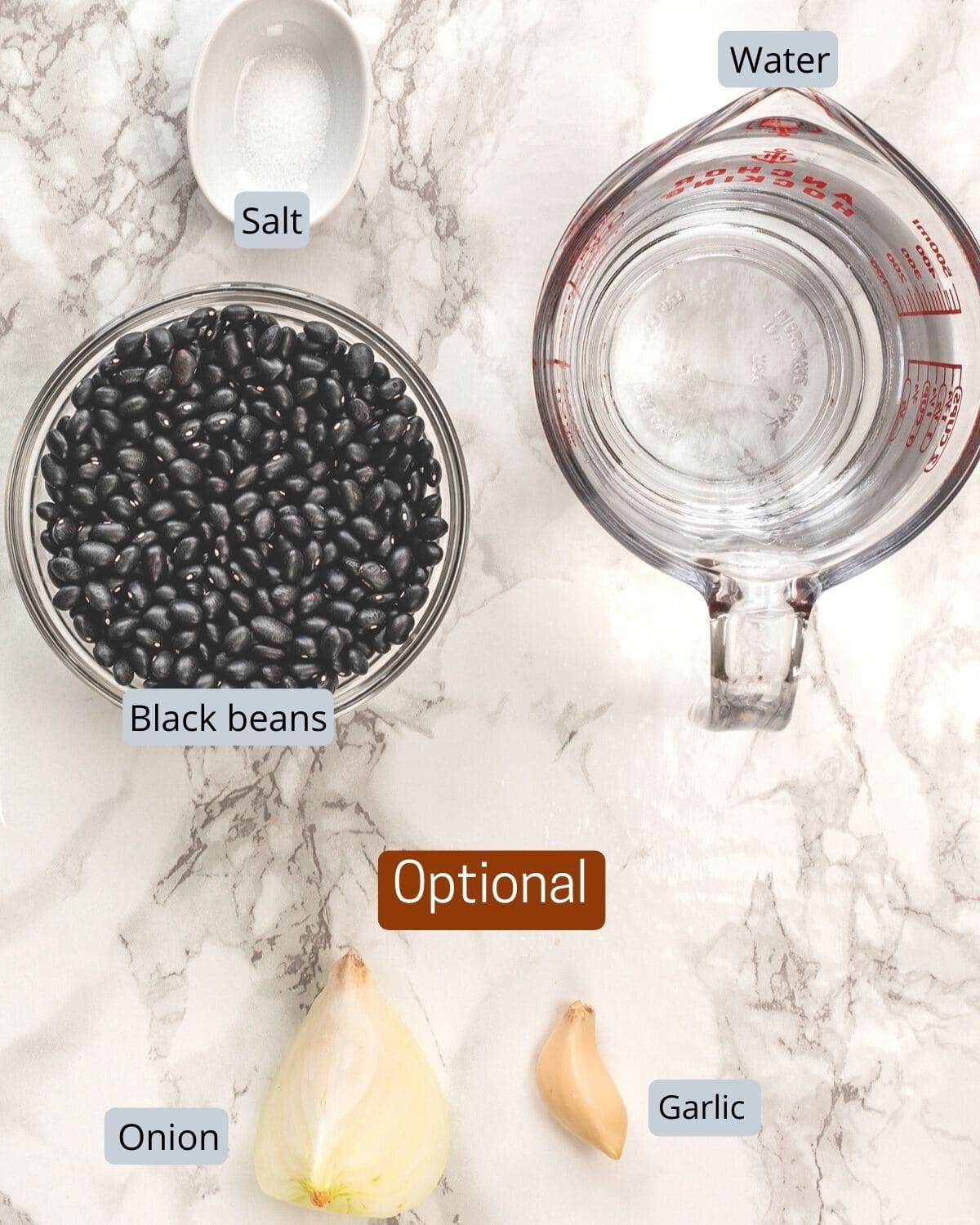 Instant pot black beans ingredients with labels on a marble surfce.