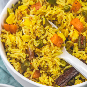 Taking a spoonful of pulao from the bowl.