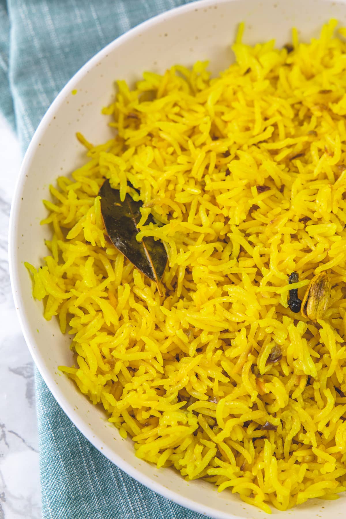 Turmeric rice in a plate with napkin under the plate.