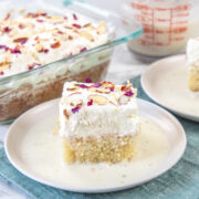 Rasmalai cake served in a plate with more cake in a pan in the back.