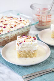 Rasmalai cake served in a plate with more cake in a pan in the back.