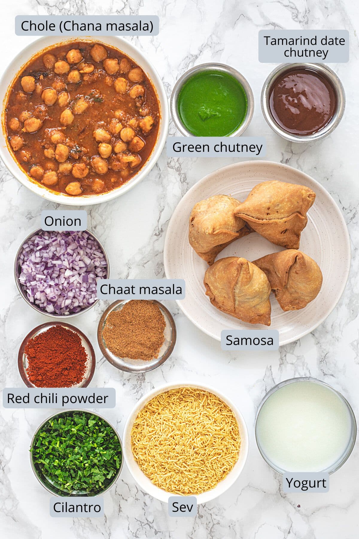 Samosa chaat elements and toppings in individual bowls and plates with labels.