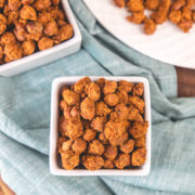 2 square bowls of masala peanuts with napkin under it.