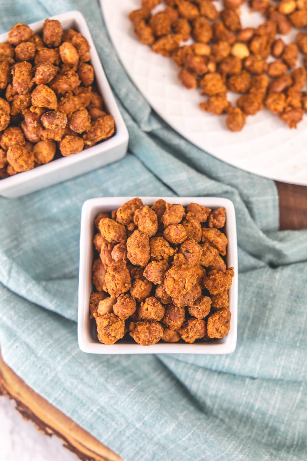 2 square bowls of masala peanuts with napkin under it.