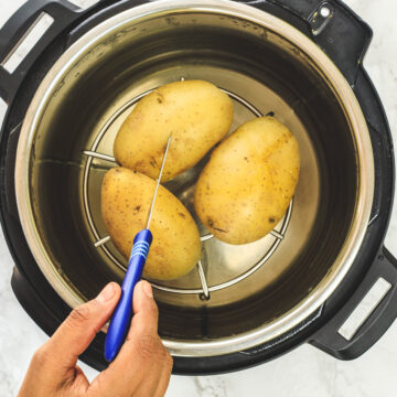 Boiled potatoes in instant pot and inserting a knife into a potato.
