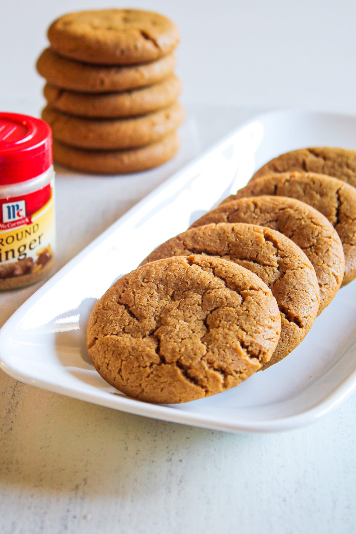 5 eggless ginger cookies in a plate with a few more in the back.