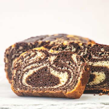 A slice of eggless marble cake on a white board.
