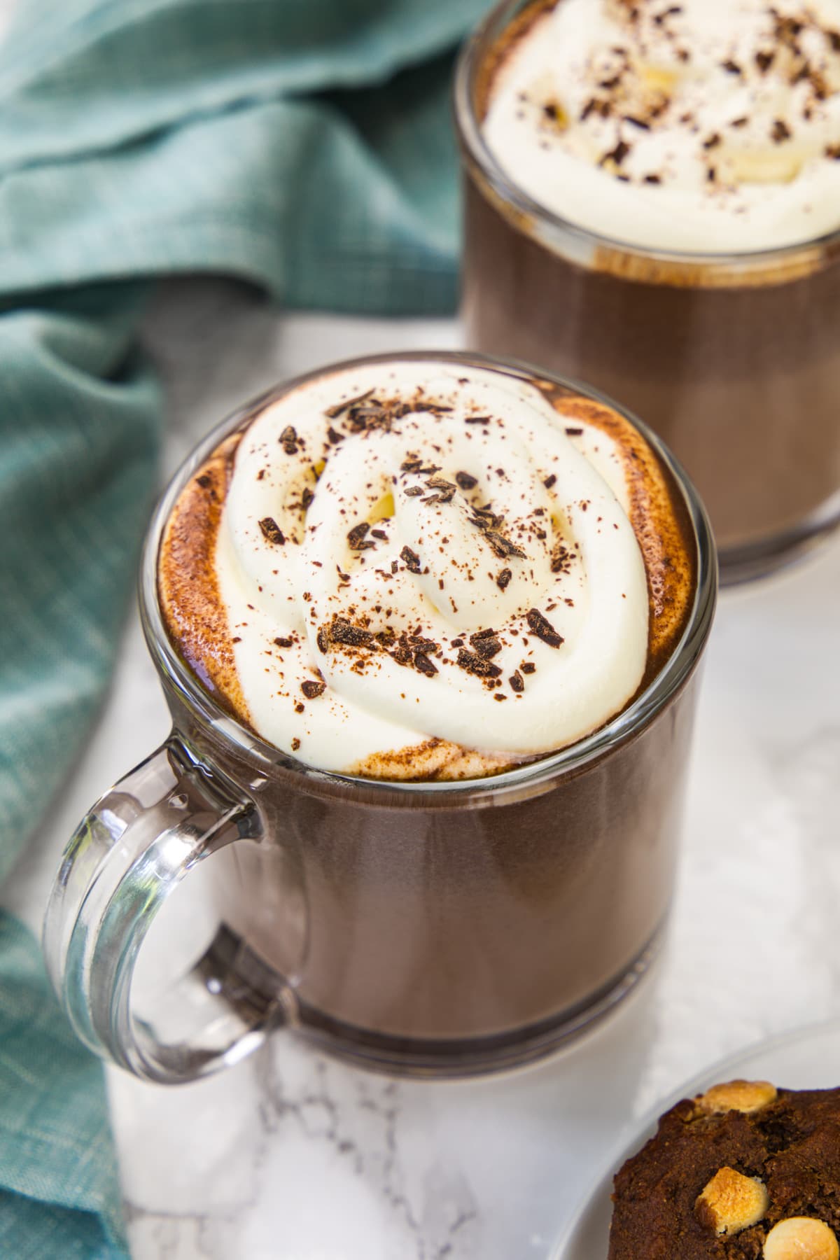 Hot chocolate topped with whipped cream and a dusting on cocoa powder.