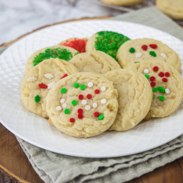 Sugar cookies in a plate with few more cookies in the back.