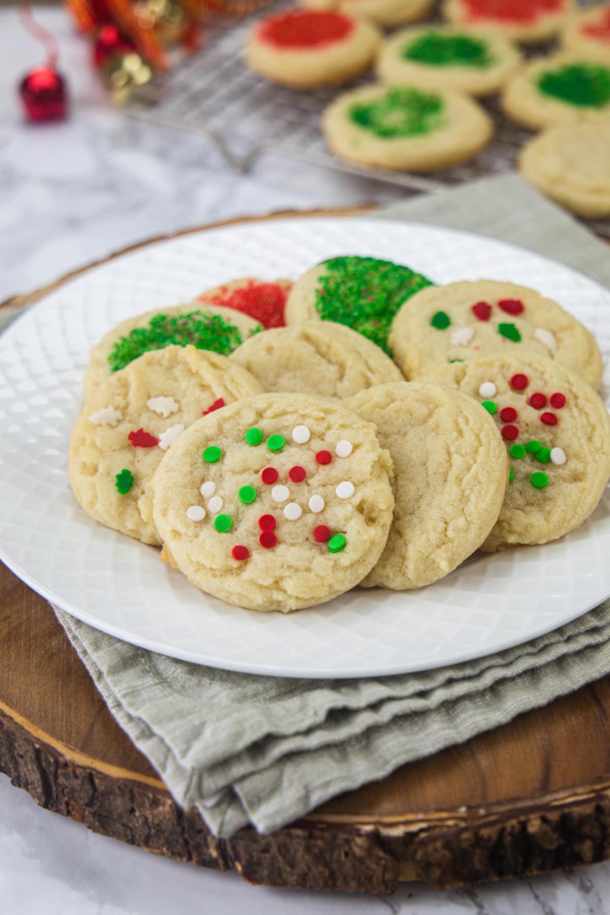 Sugar cookies in a plate with few more cookies in the back.