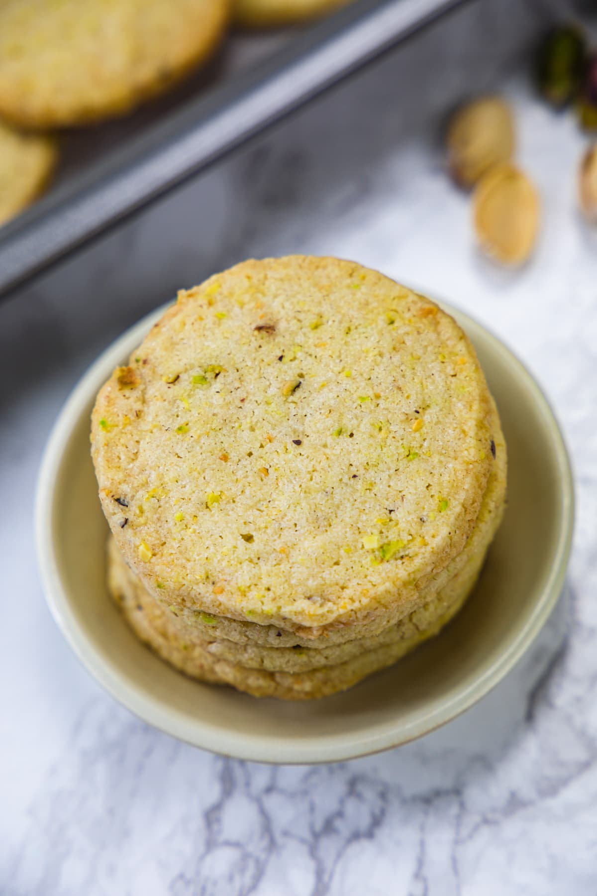 A stack of pistachio cookies in a small plate.