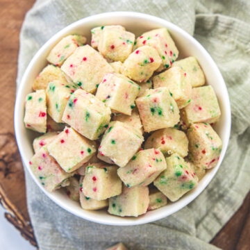 Shortbread bites in a bowl, napkin under it and a few bites on the napkin.