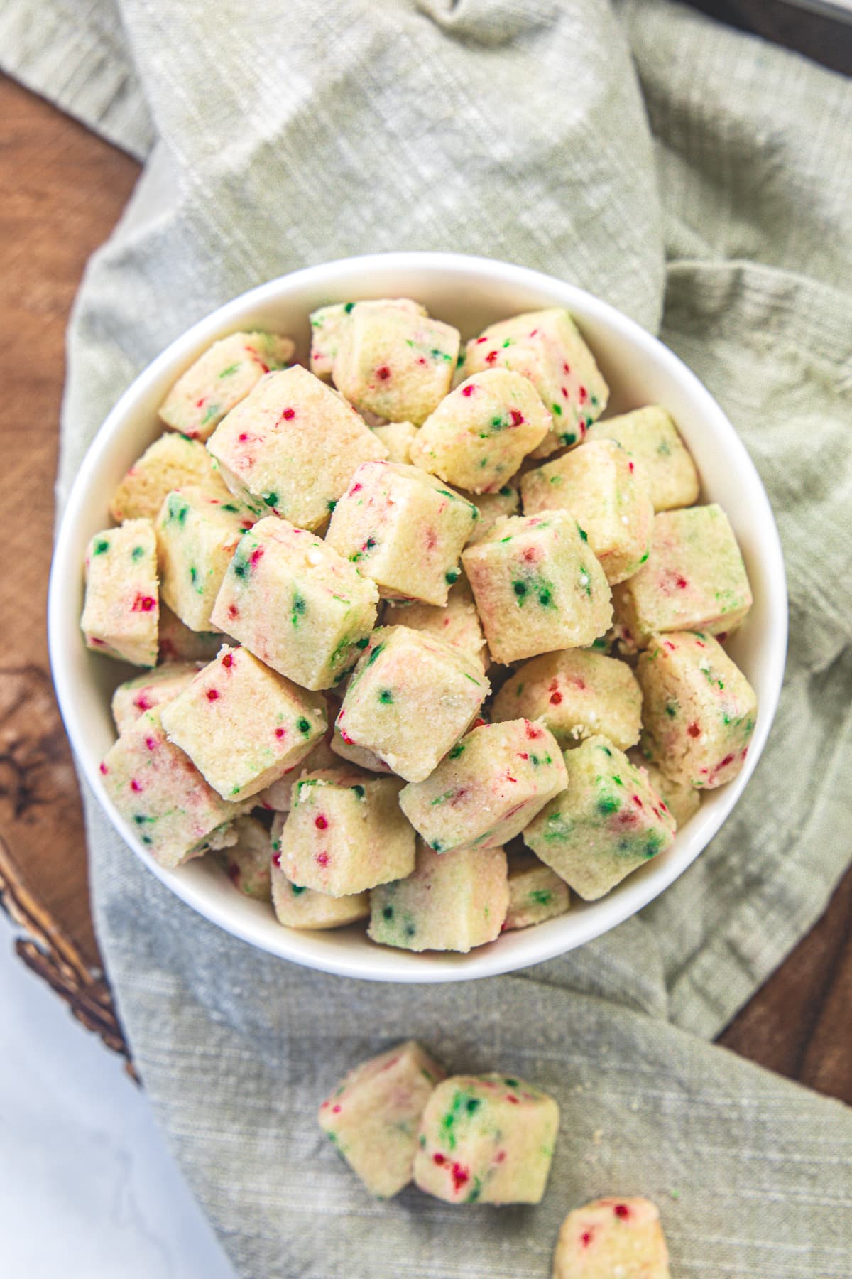 Shortbread bites in a bowl, napkin under it and a few bites on the napkin.