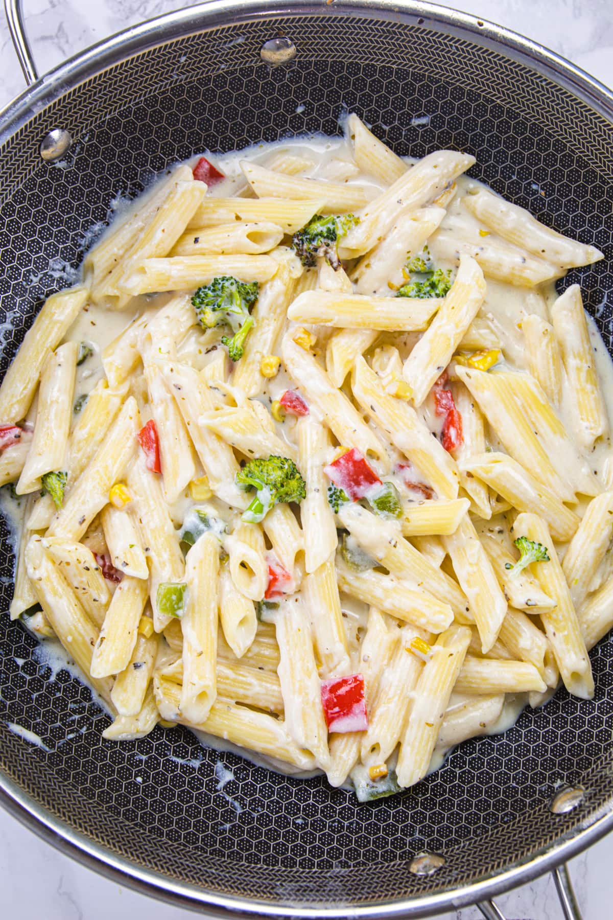 White sauce pasta in a black pan.