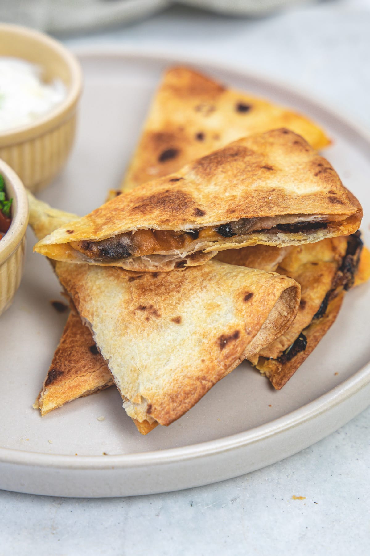 A stack of quesadilla triangles in a plate.