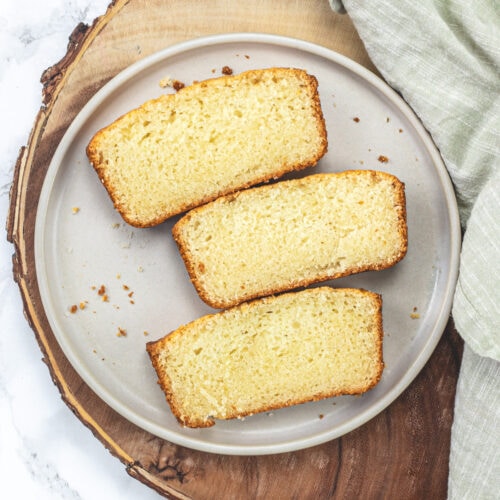 3 slices of eggless pound cake in a plate with napkin on the side.