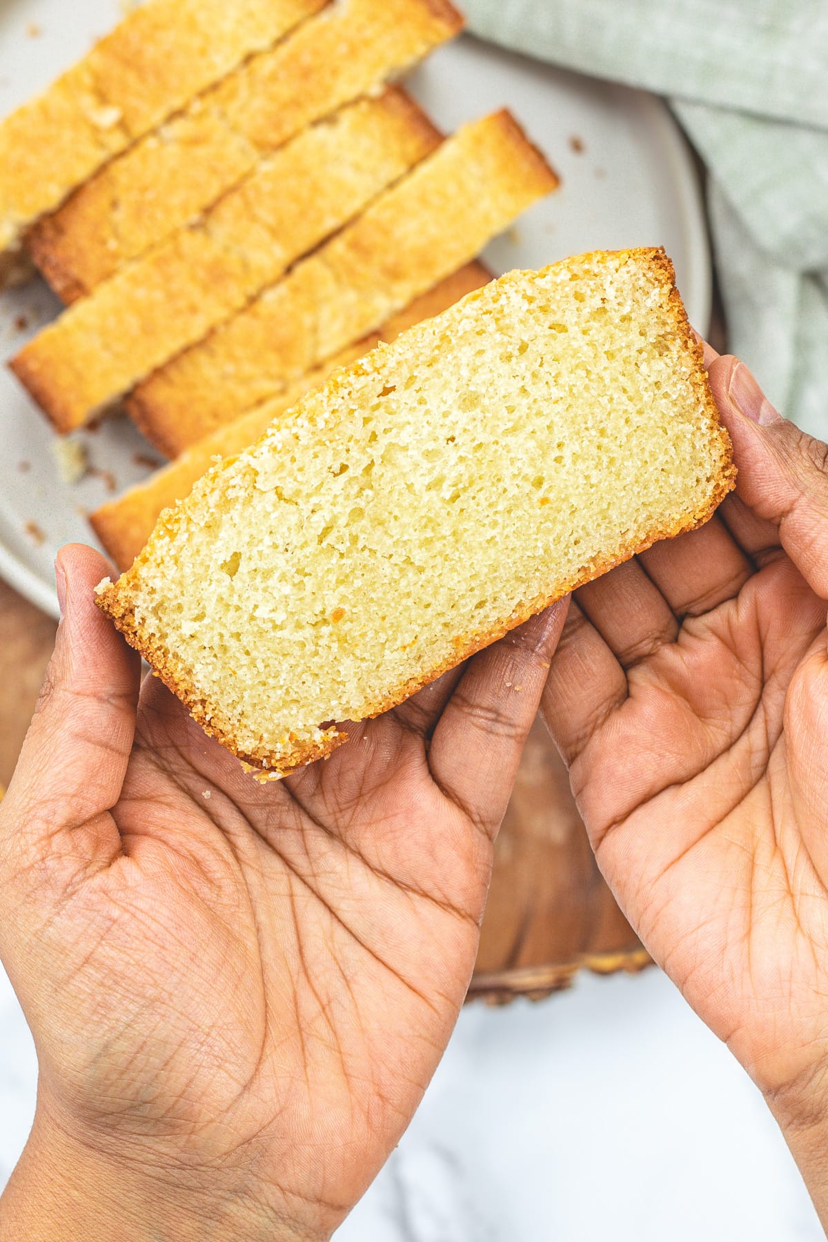 A slice of eggless pound cake in a hand.