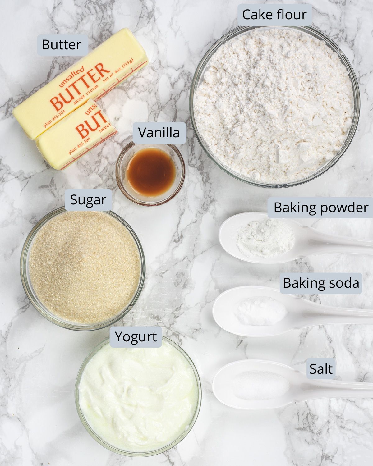 Eggless pound cake ingredients in bowls and spoons with labels.