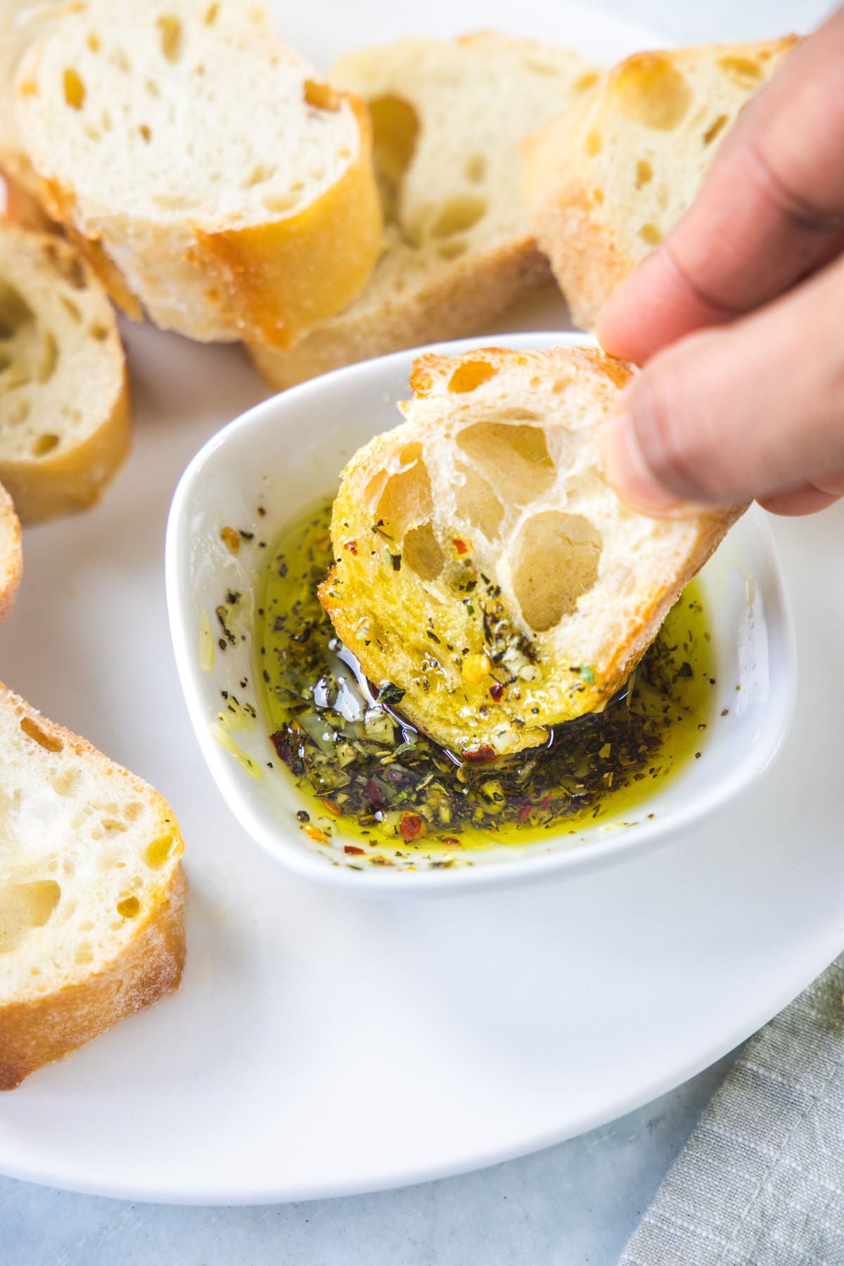 A bread dipped into olive oil bread dip.