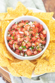 Pico de gallo served in a bowl with tortilla chips on the side.