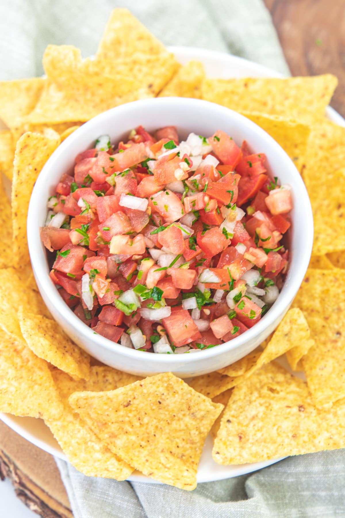 Pico de gallo served in a bowl with tortilla chips on the side.